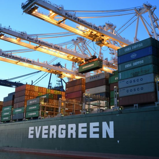 An Evergreen container ship loading at the Port of Baltimore during daytime.