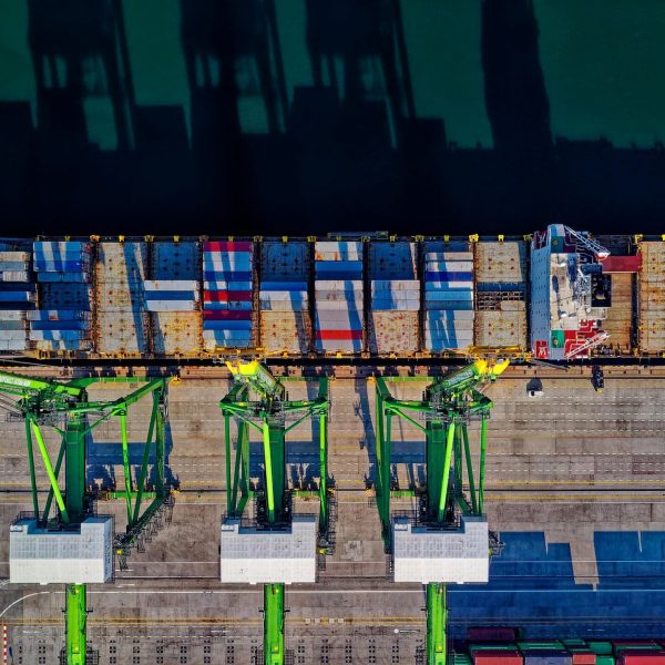 High angle aerial view of a cargo ship at a bustling port in Jakarta, showcasing global trade.