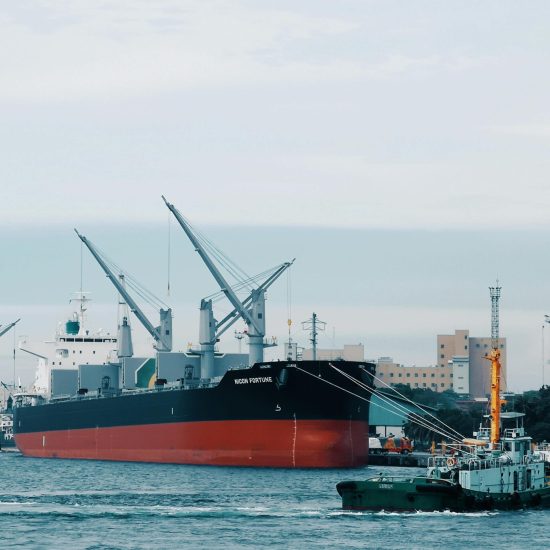 View of cargo ships docked at Davao harbor with tugboat assistance in Philippines.